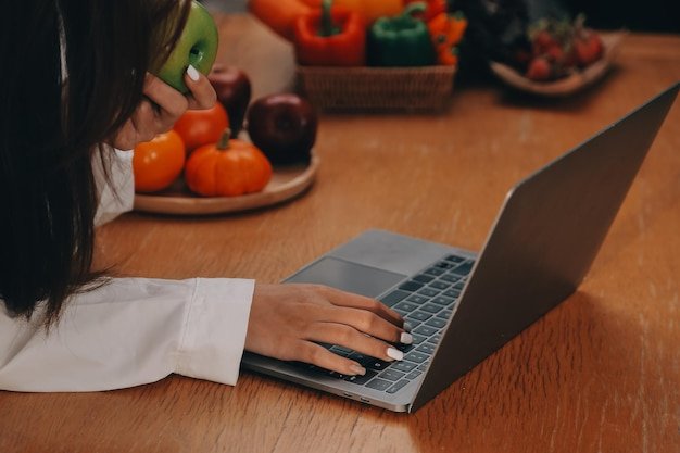 A close-up shot of a person using a laptop to browse a local online marketplace in the USA. The screen displays a variety of products from local vendors, such as fresh produce, baked goods, and handmade crafts. The focus is on the user's hands as they navigate the site, emphasizing the ease and convenience of local online shopping.