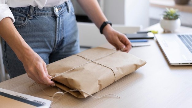A person packing a Shein order for return, showing the items neatly folded in the original packaging, along with a printed return label. The background is a clean, organized workspace.