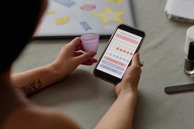 A close-up shot of a person using a smartphone to provide feedback on a recently received subscription box. The focus is on the smartphone screen displaying a feedback form with rating scales and comment fields.