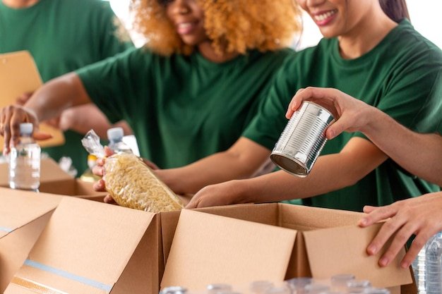 A person carefully sorting various packaging materials (cardboard boxes, plastic bags, glass bottles) into different recycling bins, highlighting the importance of proper recycling practices.
