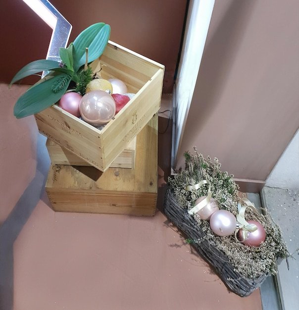 A close-up shot shows hands carefully dipping Easter eggs into bowls of natural dyes made from ingredients like beetroot juice (vibrant pink), spinach juice (soft green), and turmeric (warm yellow). The eggs are arranged in a rustic wooden bowl.