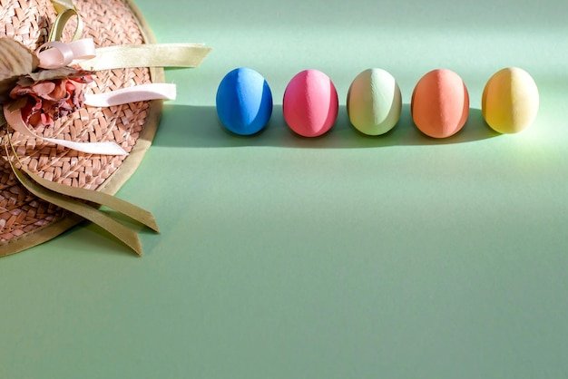 A close-up of pastel-colored Easter eggs in a basket, featuring intricate floral patterns and hand-painted designs in shades of powder blue, blush pink, lavender, and mint green.