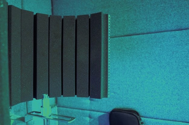 A close-up of various sound-absorbing materials, including acoustic foam panels, fabric-covered panels, and bass traps, showcasing their textures and construction, and highlighting their ability to reduce sound reflections.